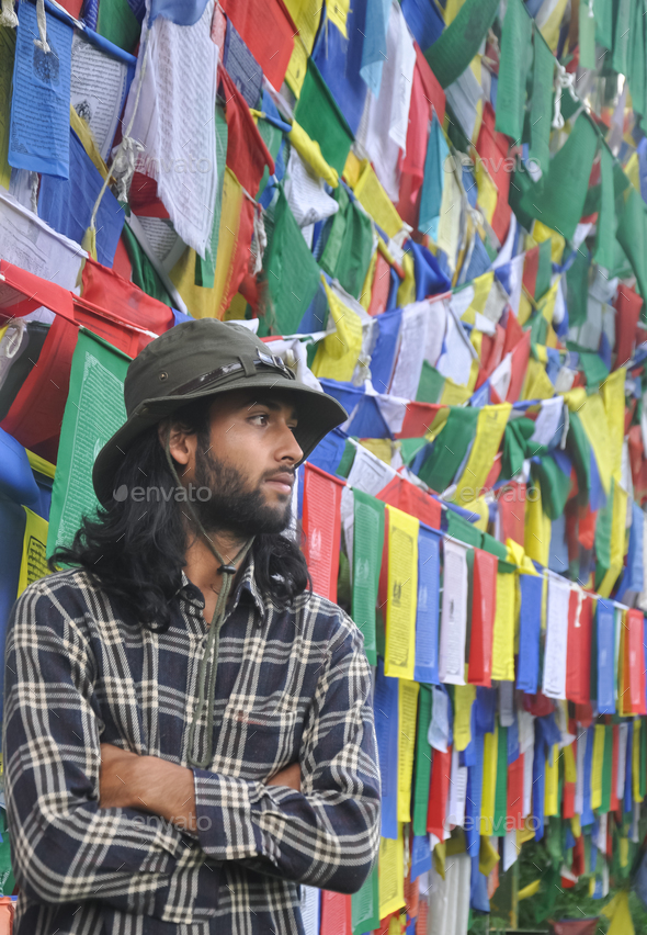 A good looking young guy looking sideways posing with his arms crossed
